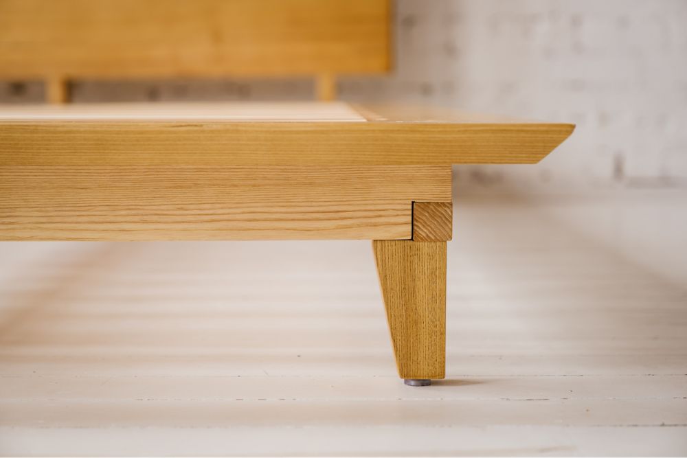 Close-up of the Timber Bed Frame's ash side rail and tapered solid timber leg