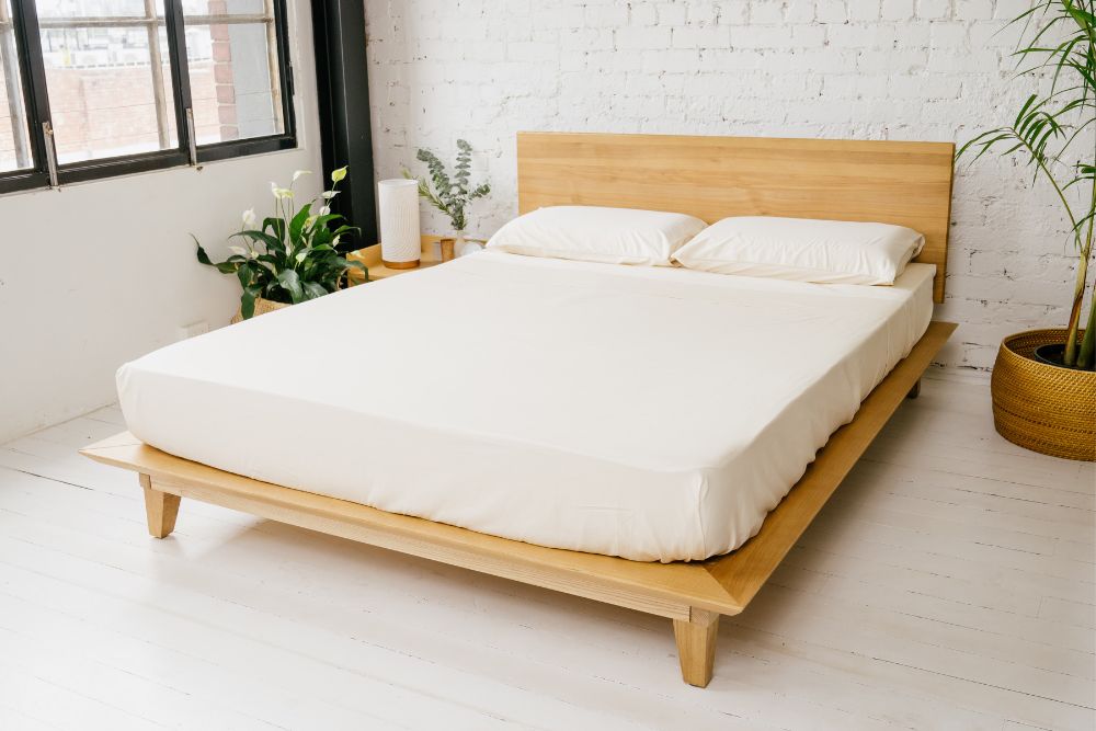 Peace Lily Timber Bed Frame with headboard, made up with cream bedding in a white brick bedroom
