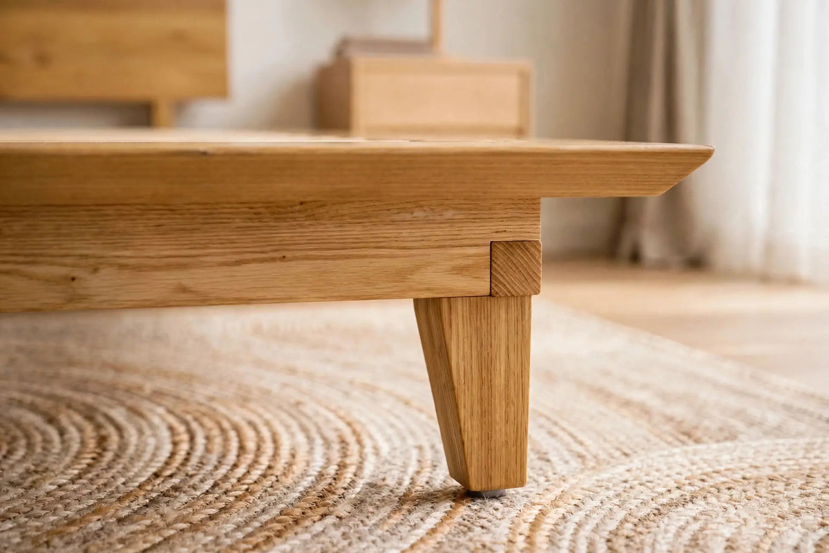 Macro detail of the Peace Lily Timber Bed Frame's tapered leg and mitred ash side rail